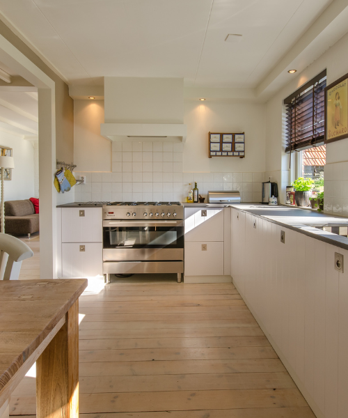 A kitchen with a wooden floor and white cabinets