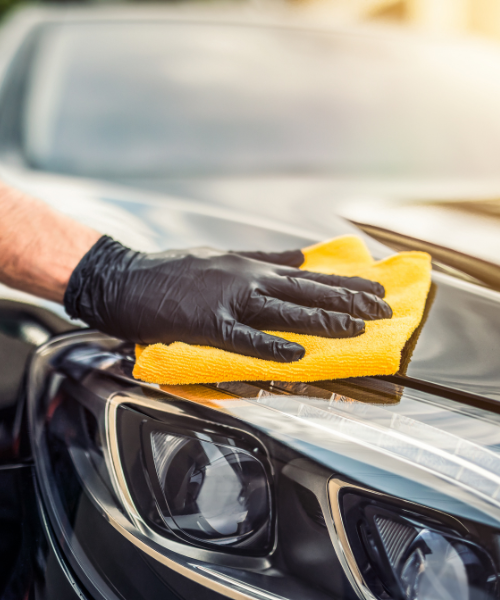 A person with a glove on top of a car